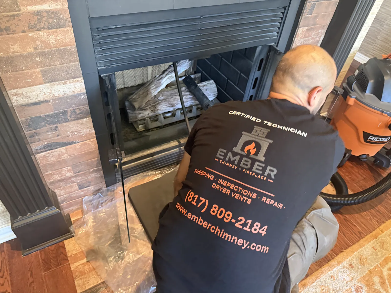 Ember certified technician kneeling at a fireplace