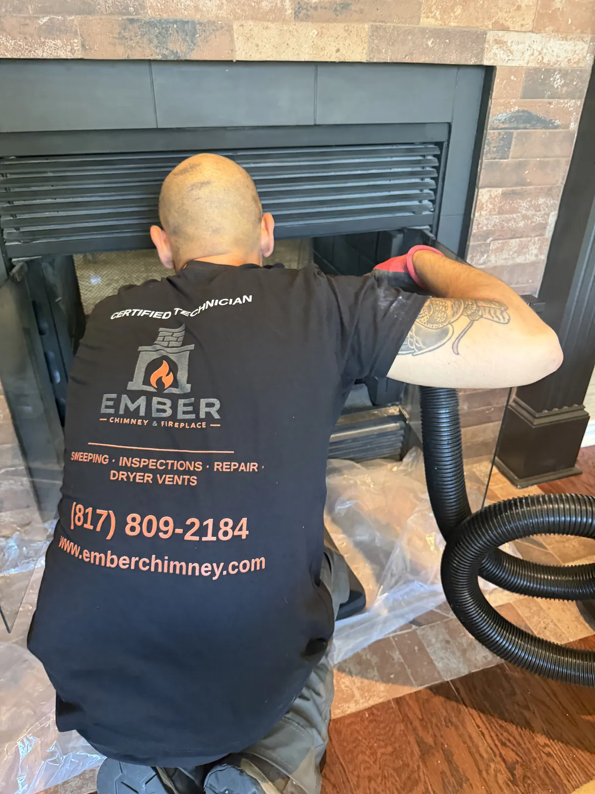 Ember technician vacuuming a fireplace