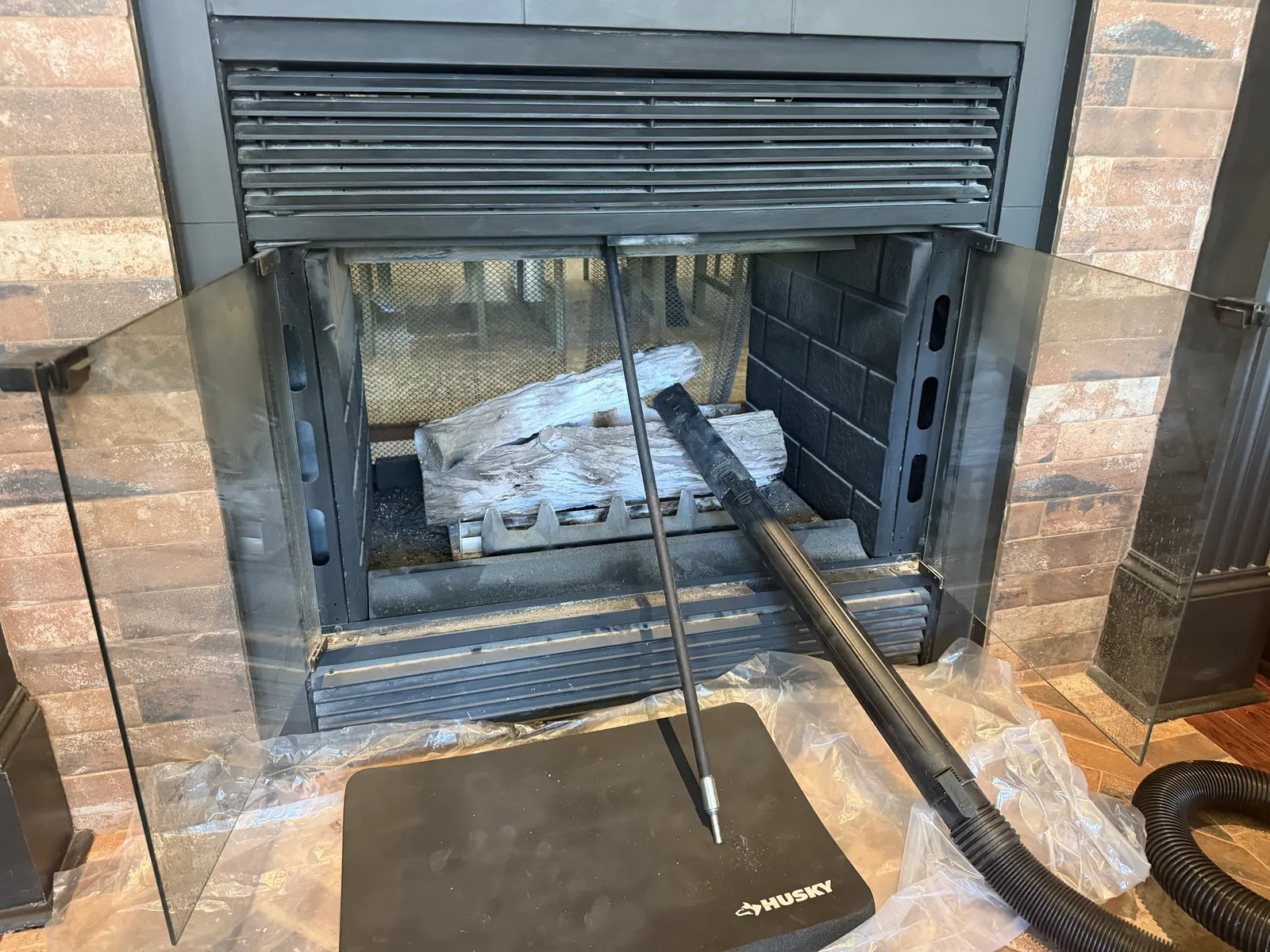 Fireplace opened for a professional sweep with drop cloths down
