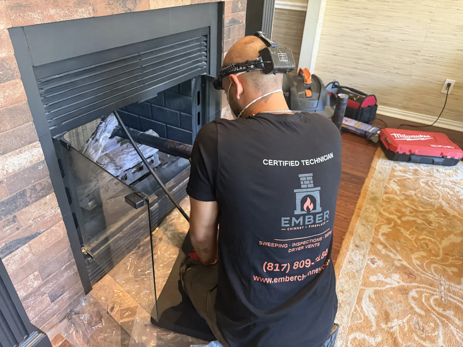 Ember technician using a vacuum wand in a fireplace