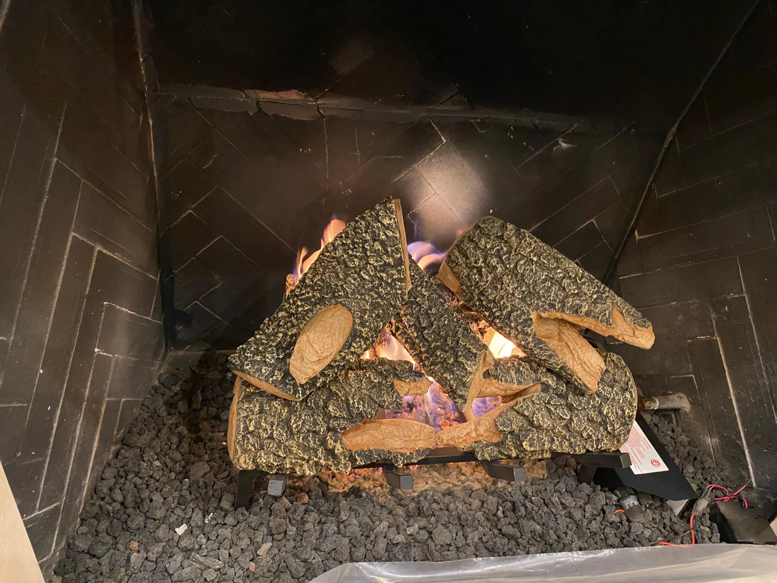Gas logs burning in a brick fireplace
